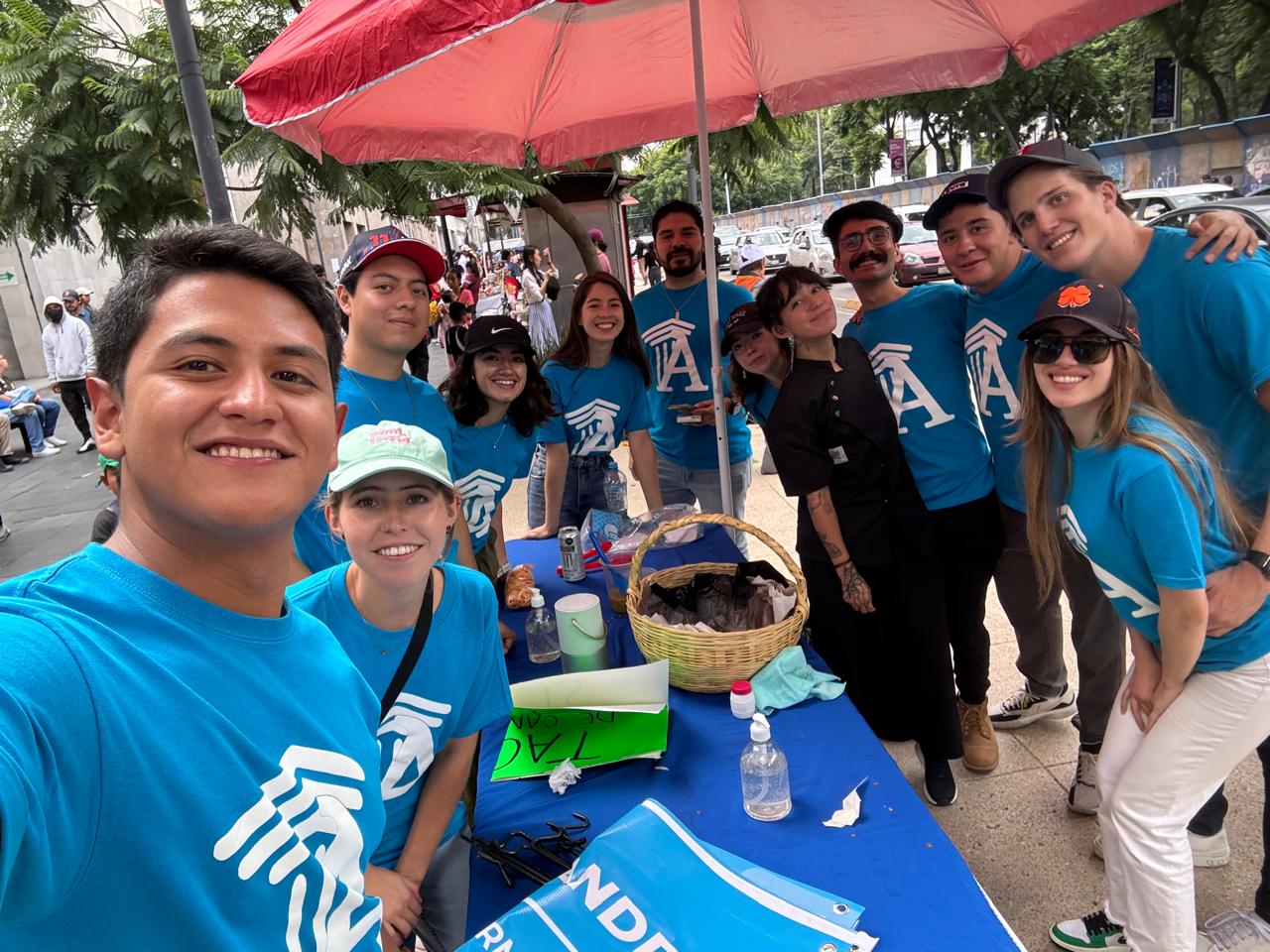 Group of Alexandr.ia team members wearing branded blue shirts at an outdoor outreach event